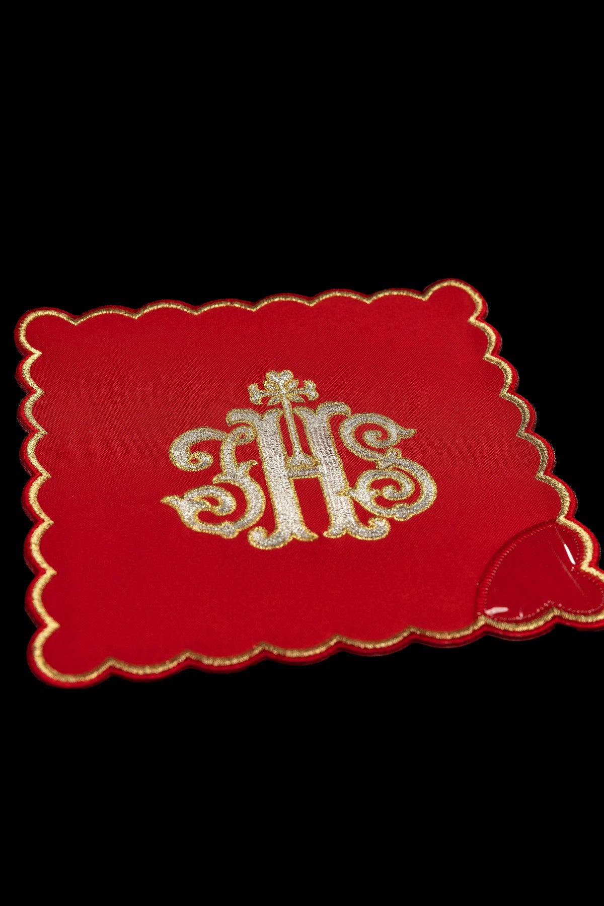 Pale de calice rouge, vue rapprochée, avec motif IHS brodé argent et or