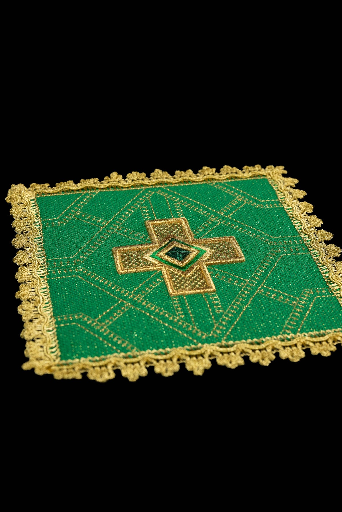 Pale de calice verte, vue rapprochée, avec croix brodée, motif géométrique et galon doré