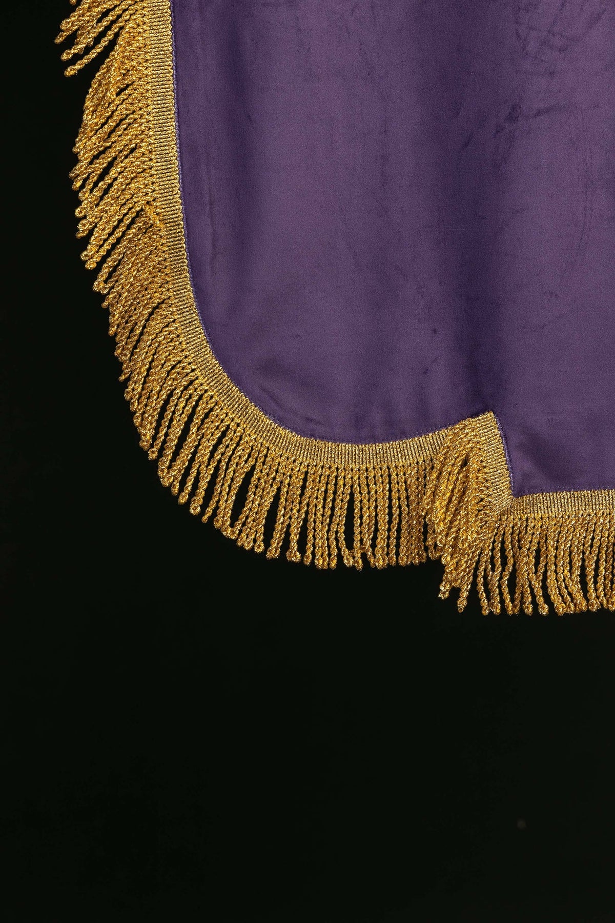 Bannière violette, gros plan des franges dorées au bord inférieur