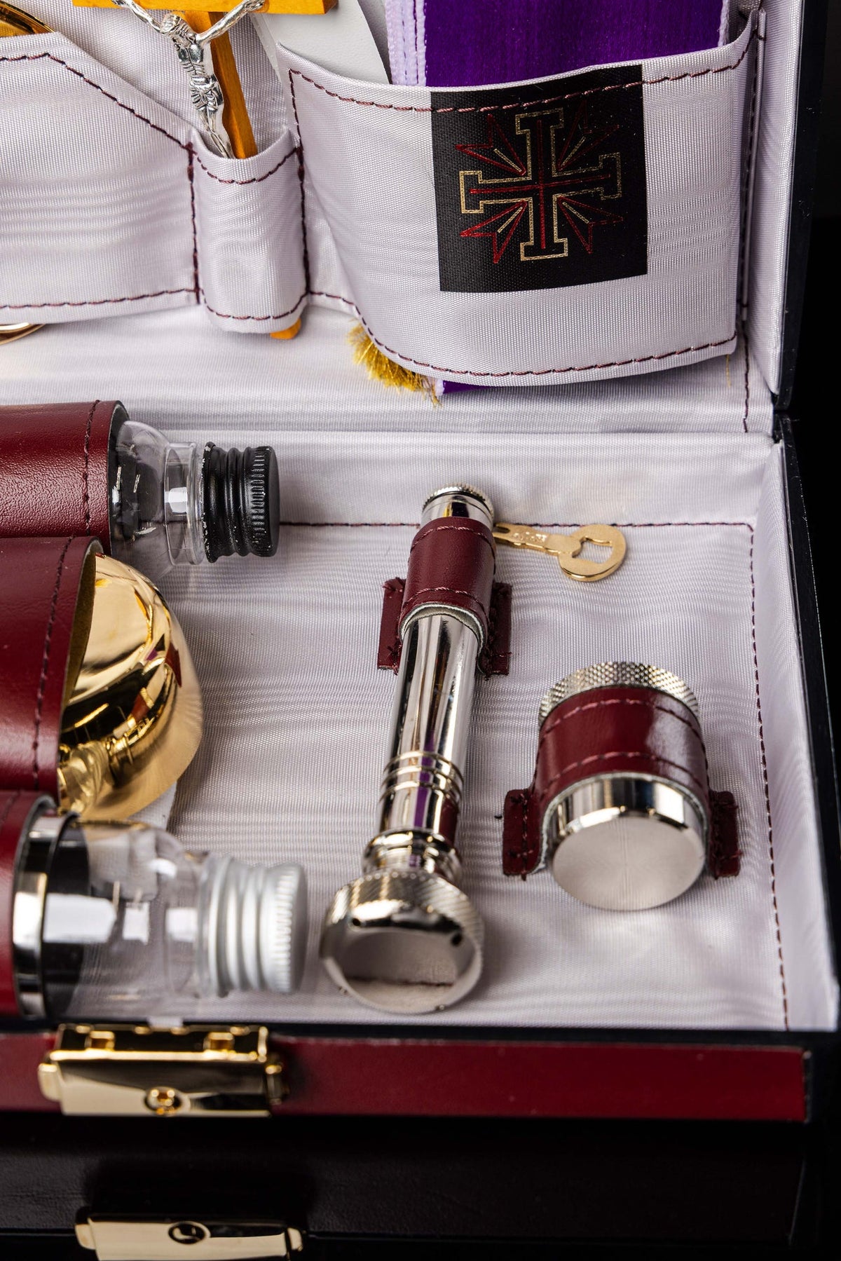 Valise liturgique, détail des flacons et accessoires métalliques dans les compartiments