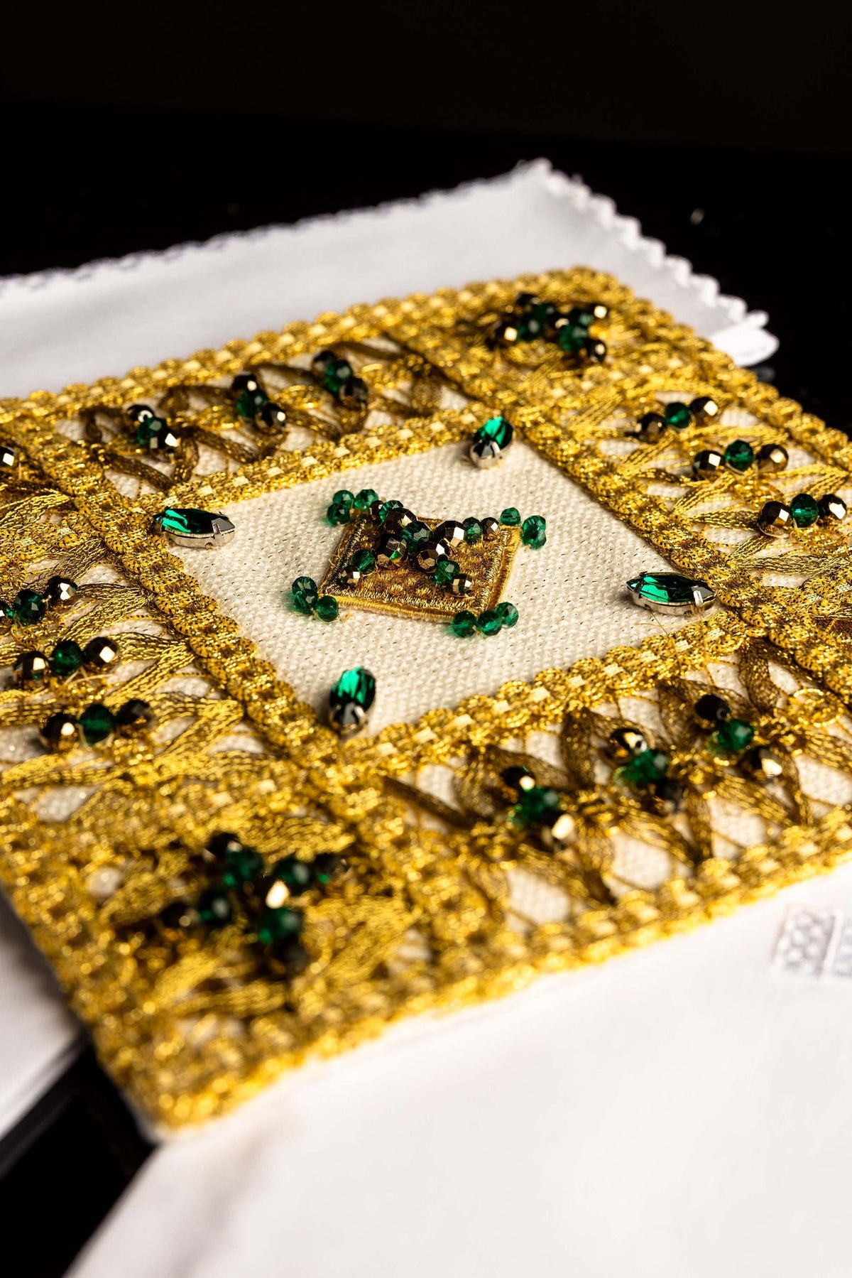 Ensemble de linges de calice, gros plan sur les broderies dorées et les perles vertes