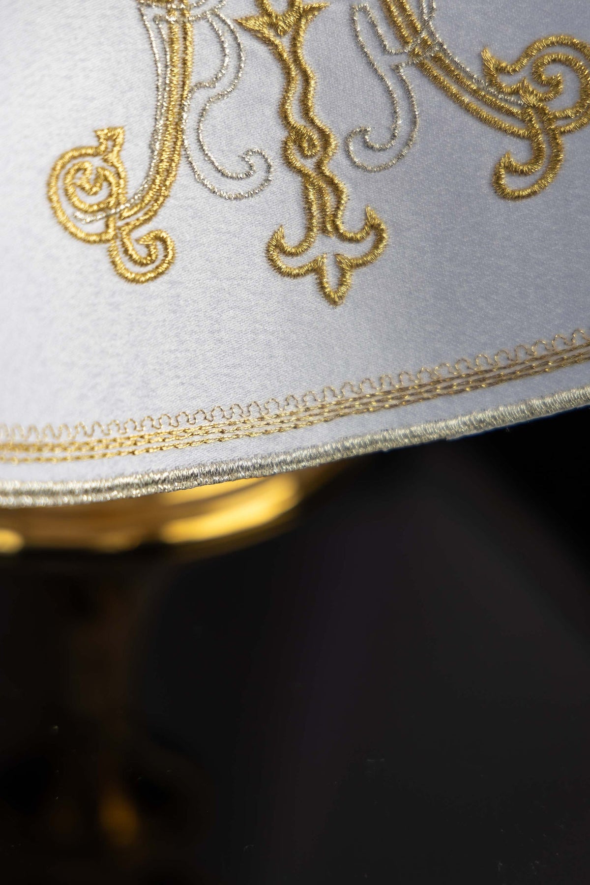Voile de ciboire rond avec broderie mariale dorée, détail de la broderie et de la bordure