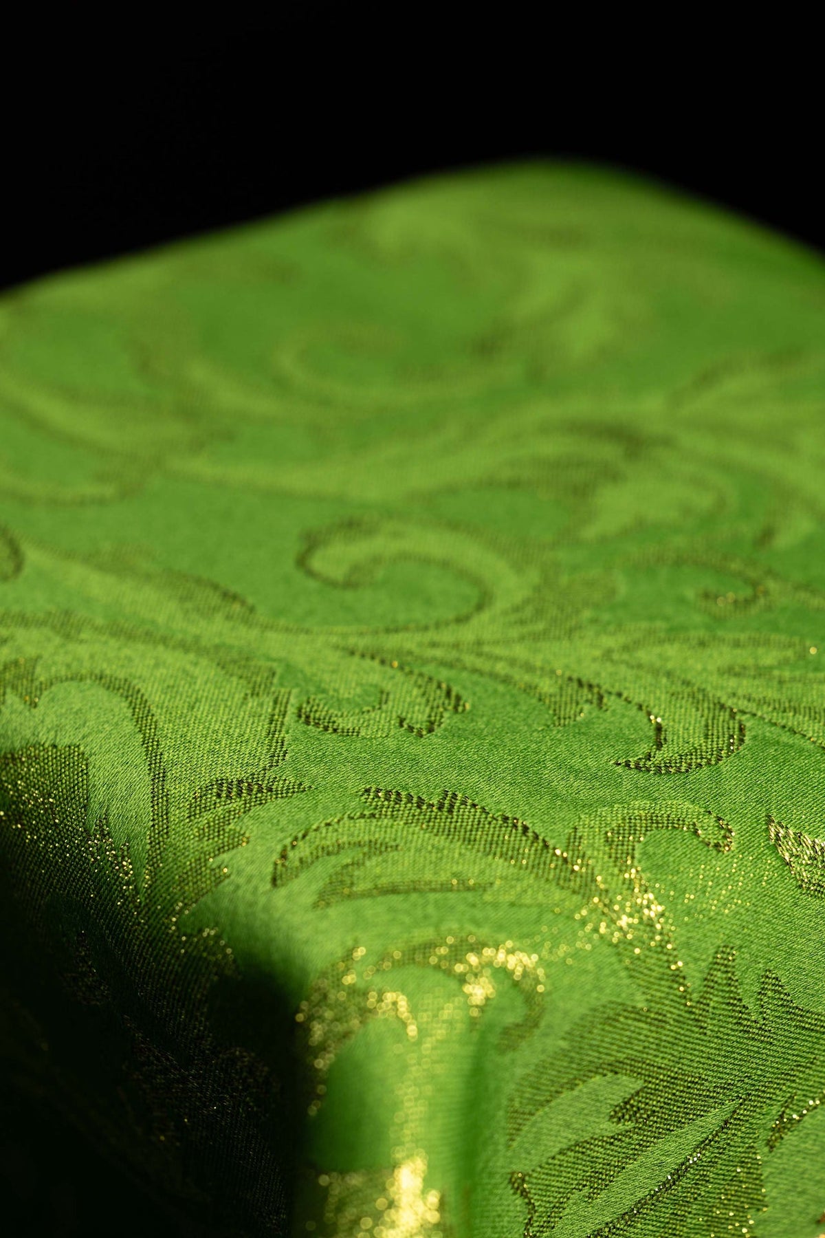 Voile de calice vert, gros plan sur le motif damassé du tissu