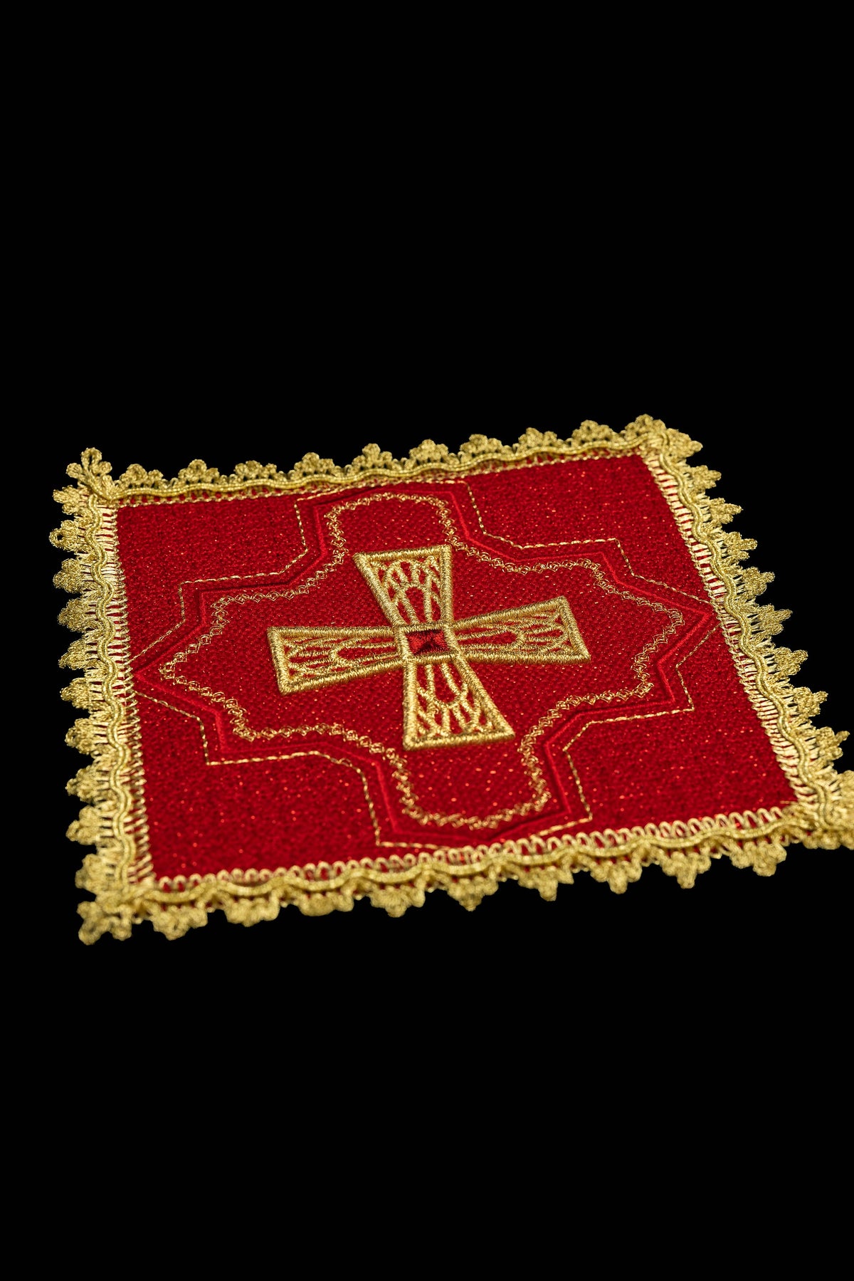 Pale de calice rouge avec croix brodée et galon doré, vue rapprochée
