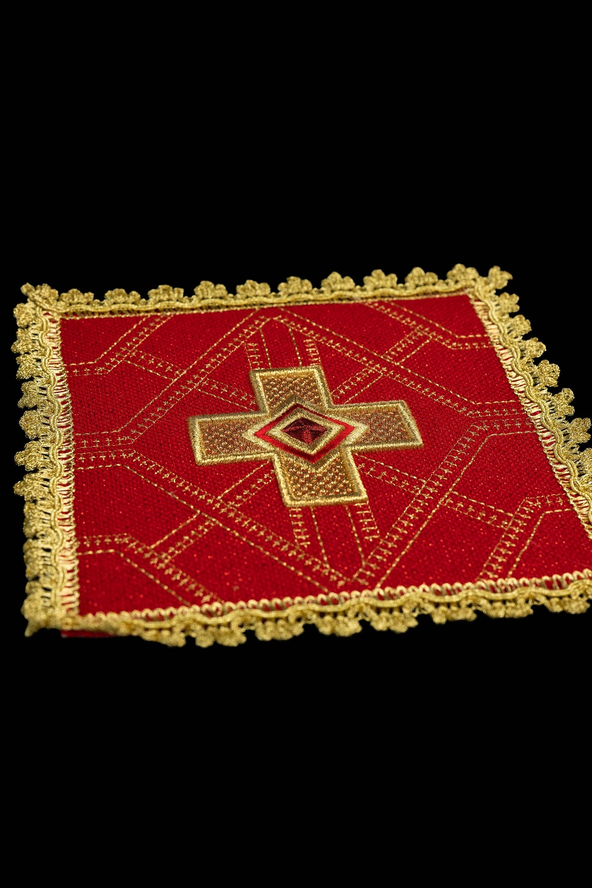Pale de calice rouge, vue rapprochée, avec croix brodée et galon doré