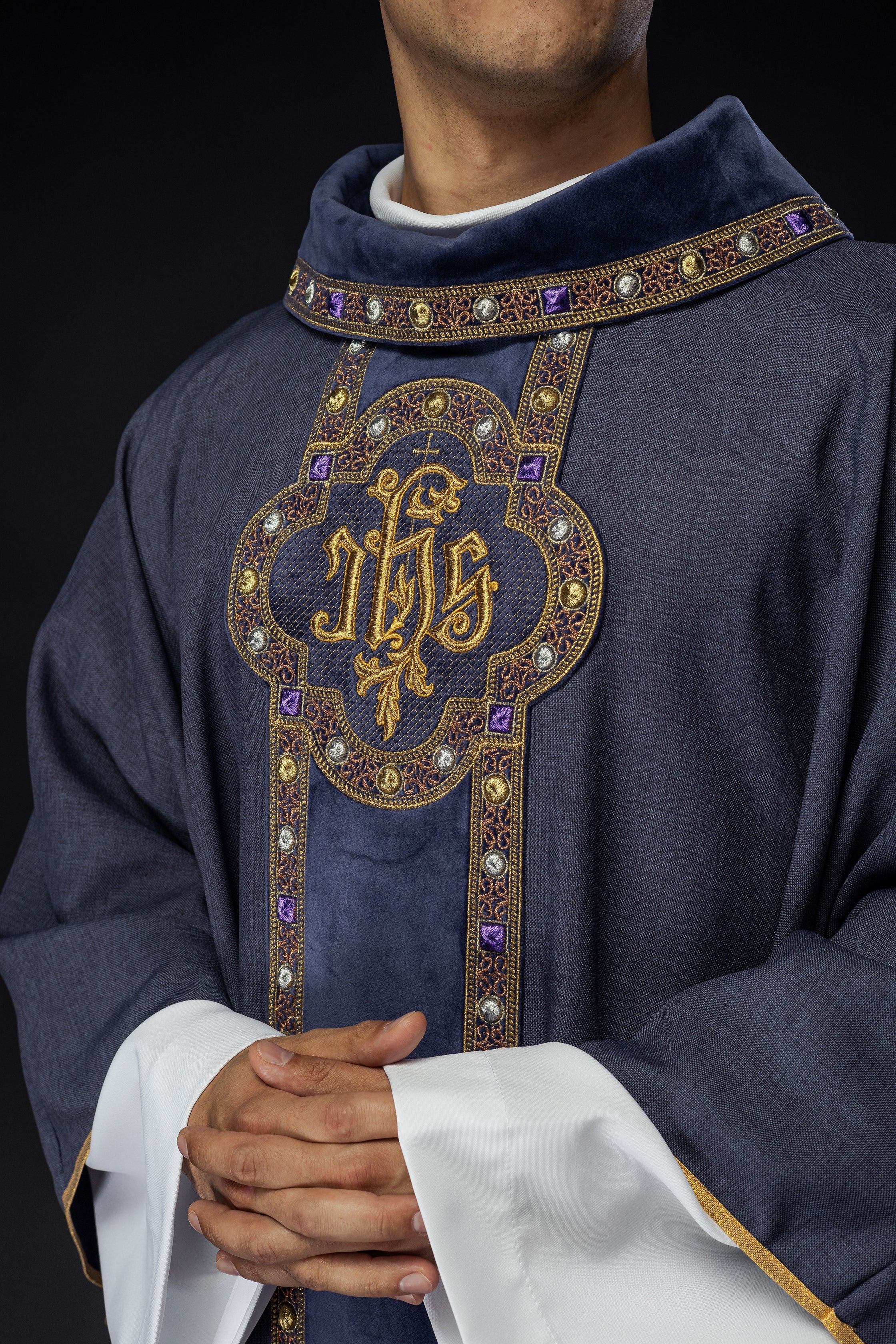 Chasuble avec une ceinture et un galon richement brodés autour de la broderie IHS et un col violet