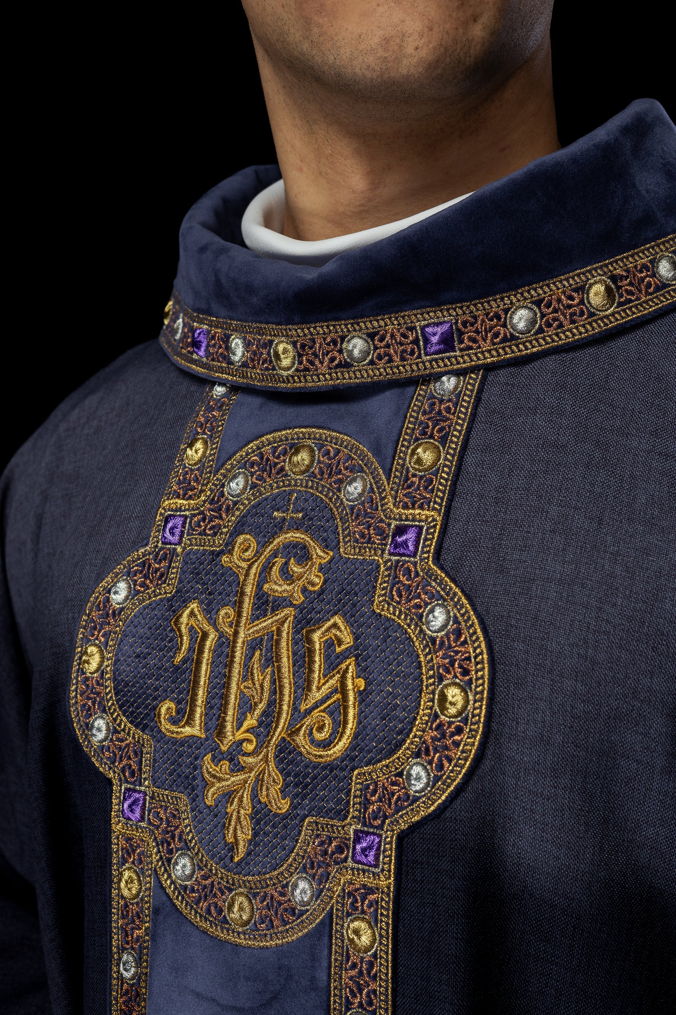 Chasuble avec une ceinture et un galon richement brodés autour de la broderie IHS et un col violet