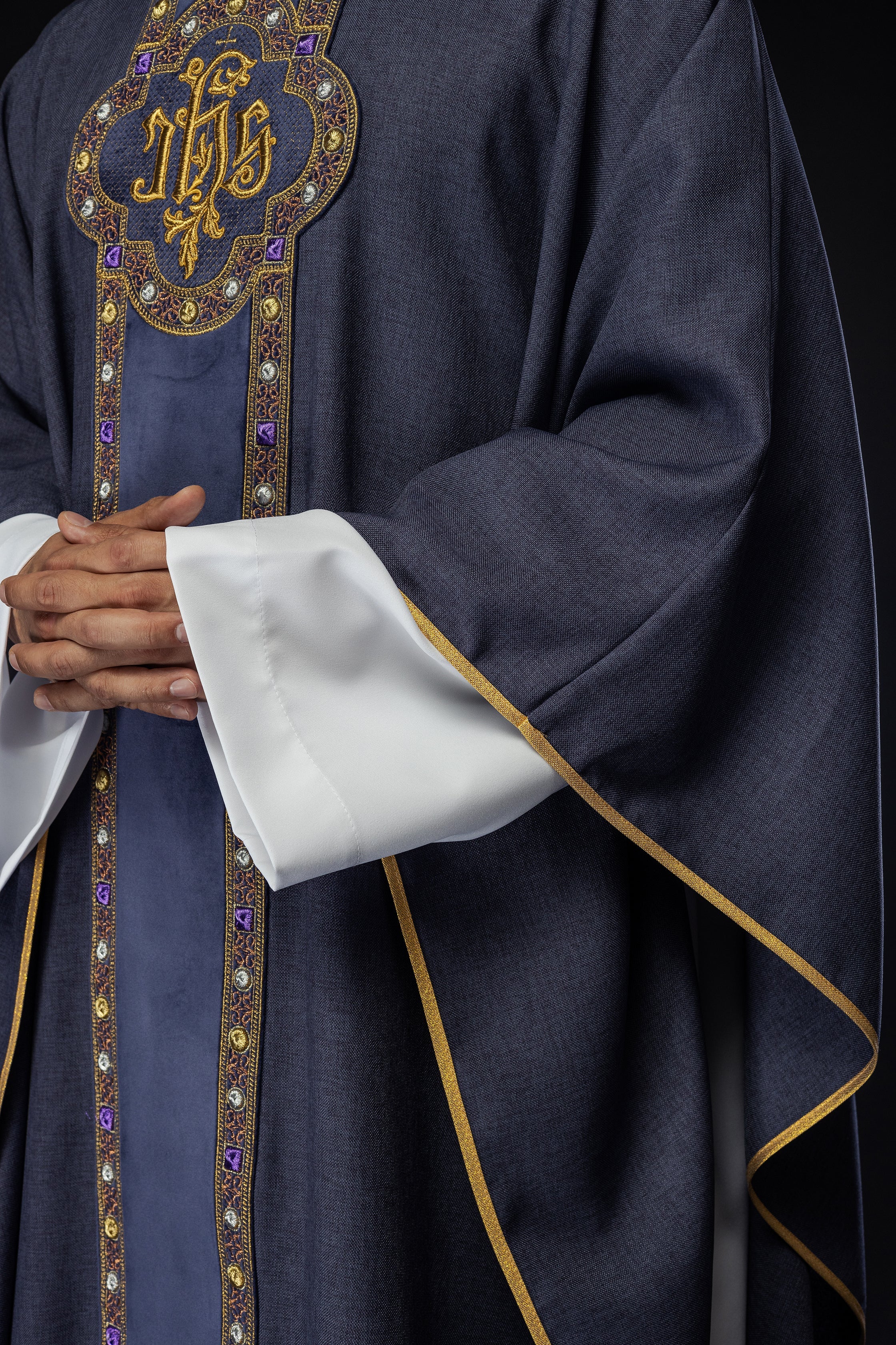 Chasuble avec une ceinture et un galon richement brodés autour de la broderie IHS et un col violet