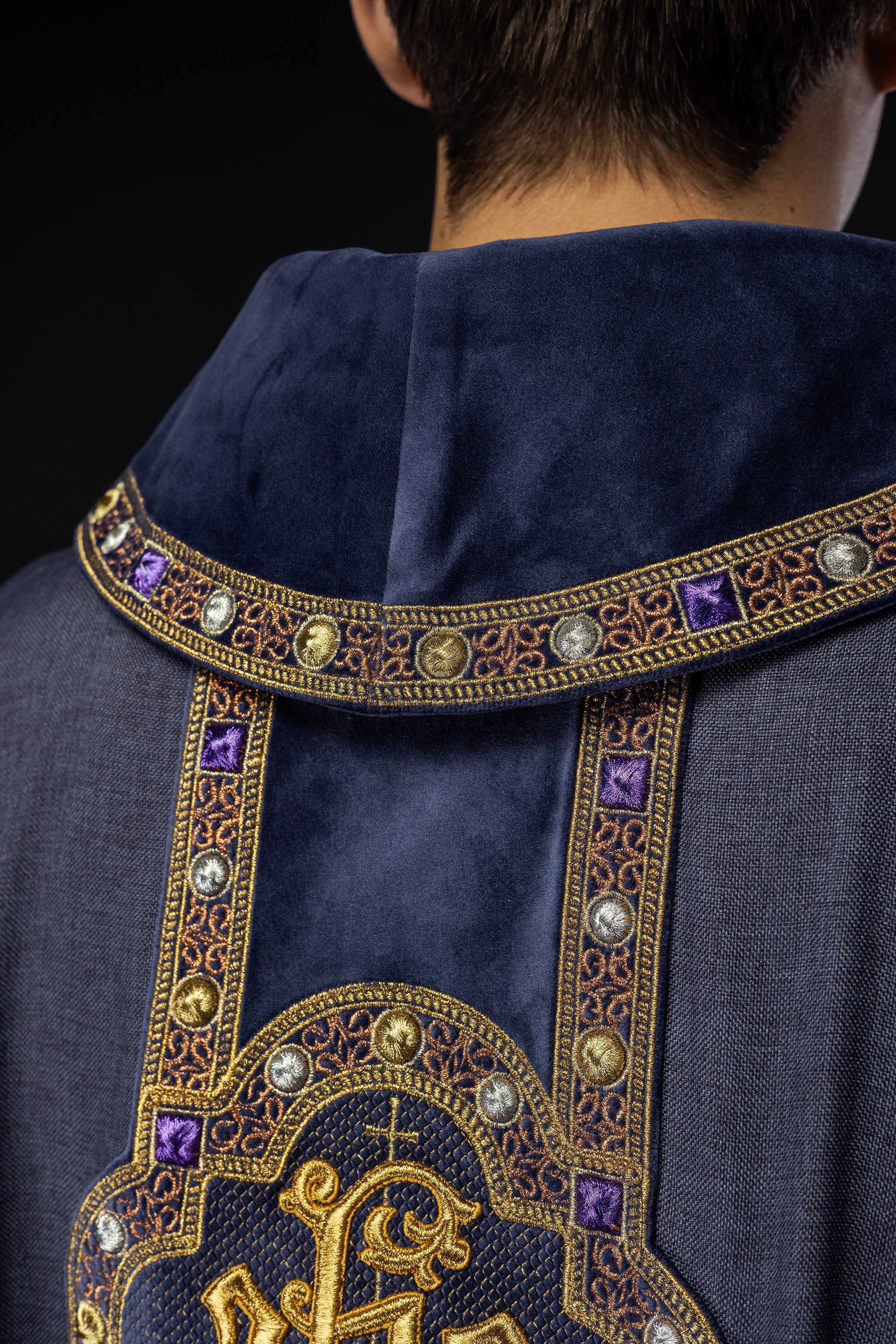 Chasuble avec une ceinture et un galon richement brodés autour de la broderie IHS et un col violet