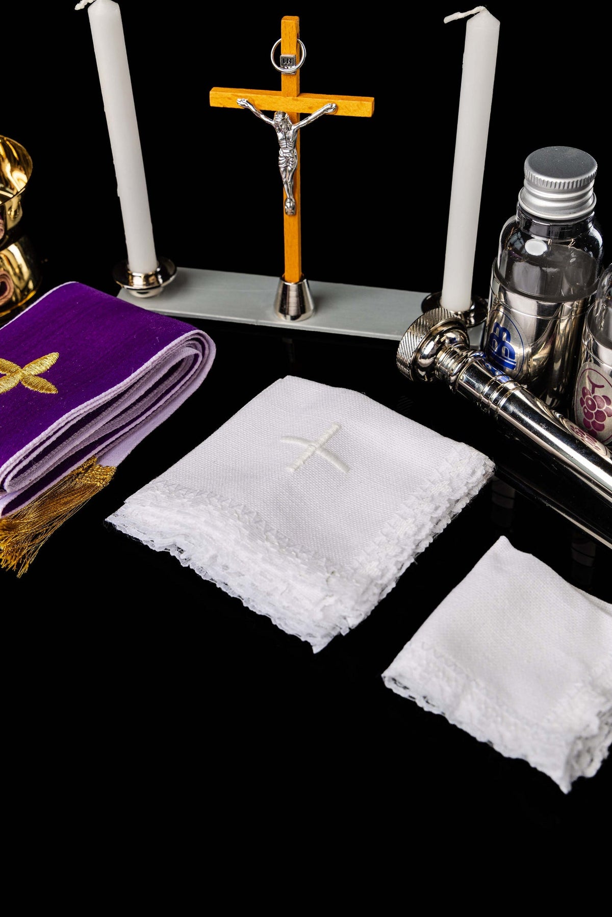 Valise liturgique, détail du crucifix, des bougies, des flacons et du linge blanc