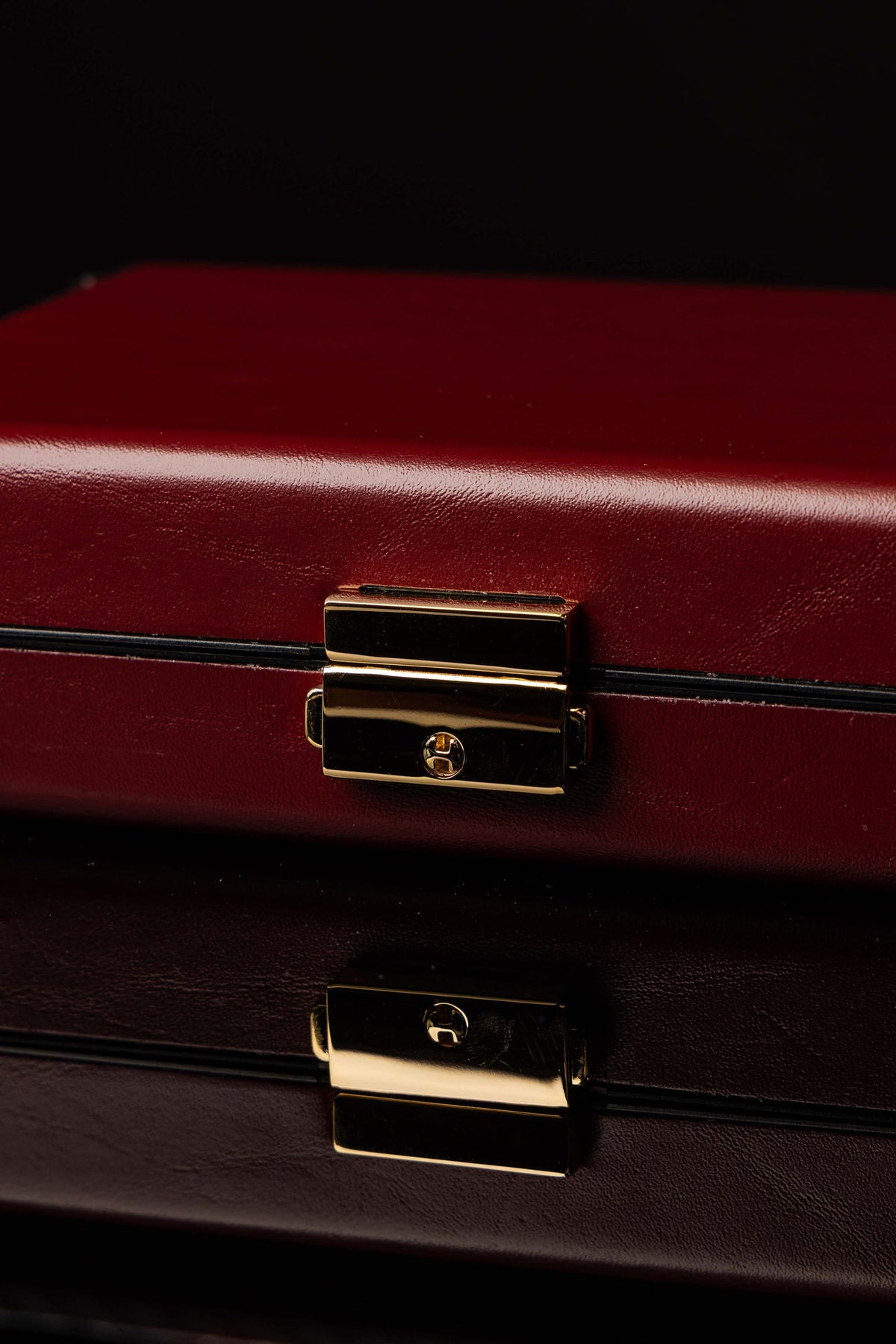 Valise liturgique rouge, gros plan sur la serrure dorée