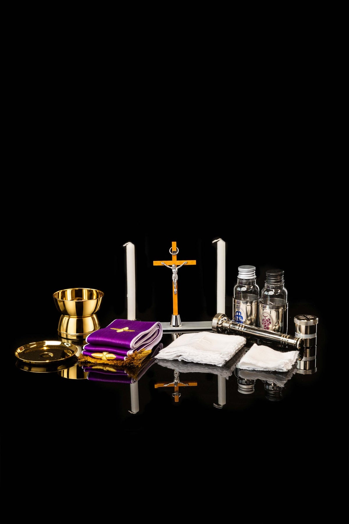 Valise liturgique ouverte présentant l’ensemble des accessoires dorés, violets et blancs