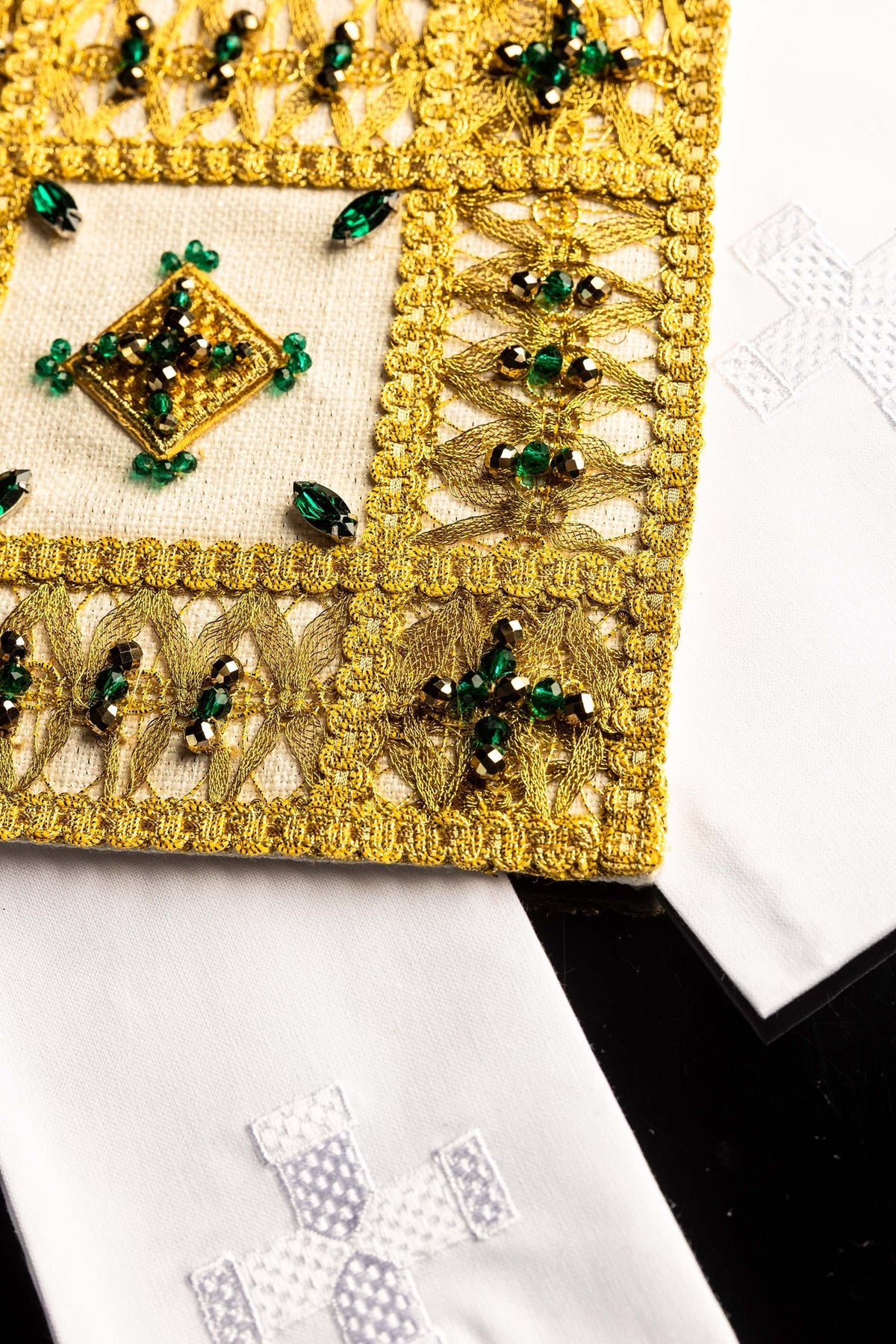 Ensemble de linges de calice, détail latéral de la broderie dorée et de la croix blanche