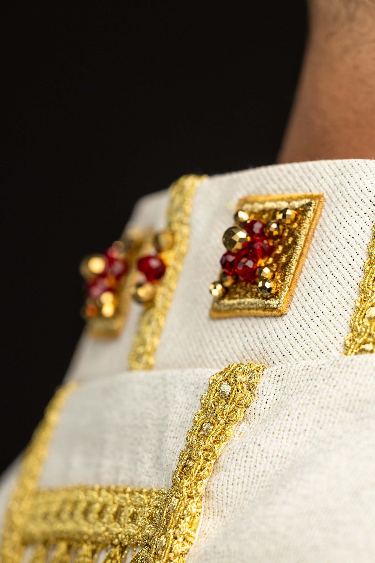 Chasuble faite à la main avec des pierres naturelles, détail du galon doré et des ornements rouges