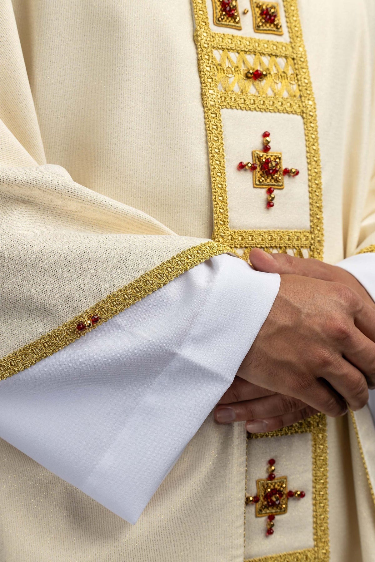 Chasuble, gros plan sur la croix centrale en pierres rouges et dorées