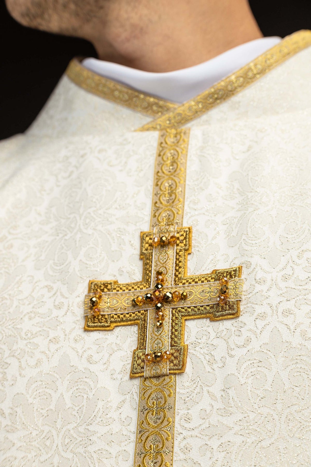 Chasuble ivoire, gros plan sur l’encolure et la croix ornée de pierres naturelles