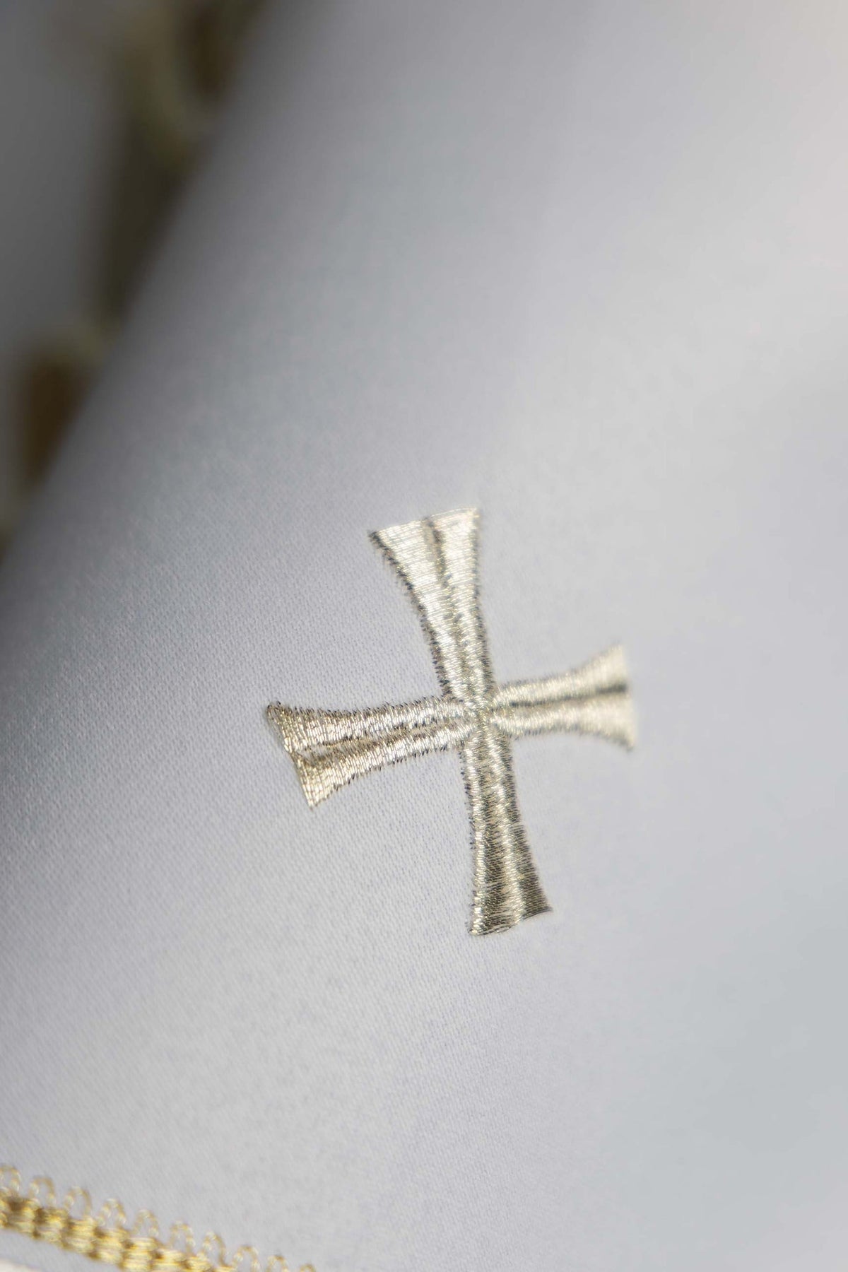 Voile de ciboire blanc, gros plan sur une croix brodée argentée