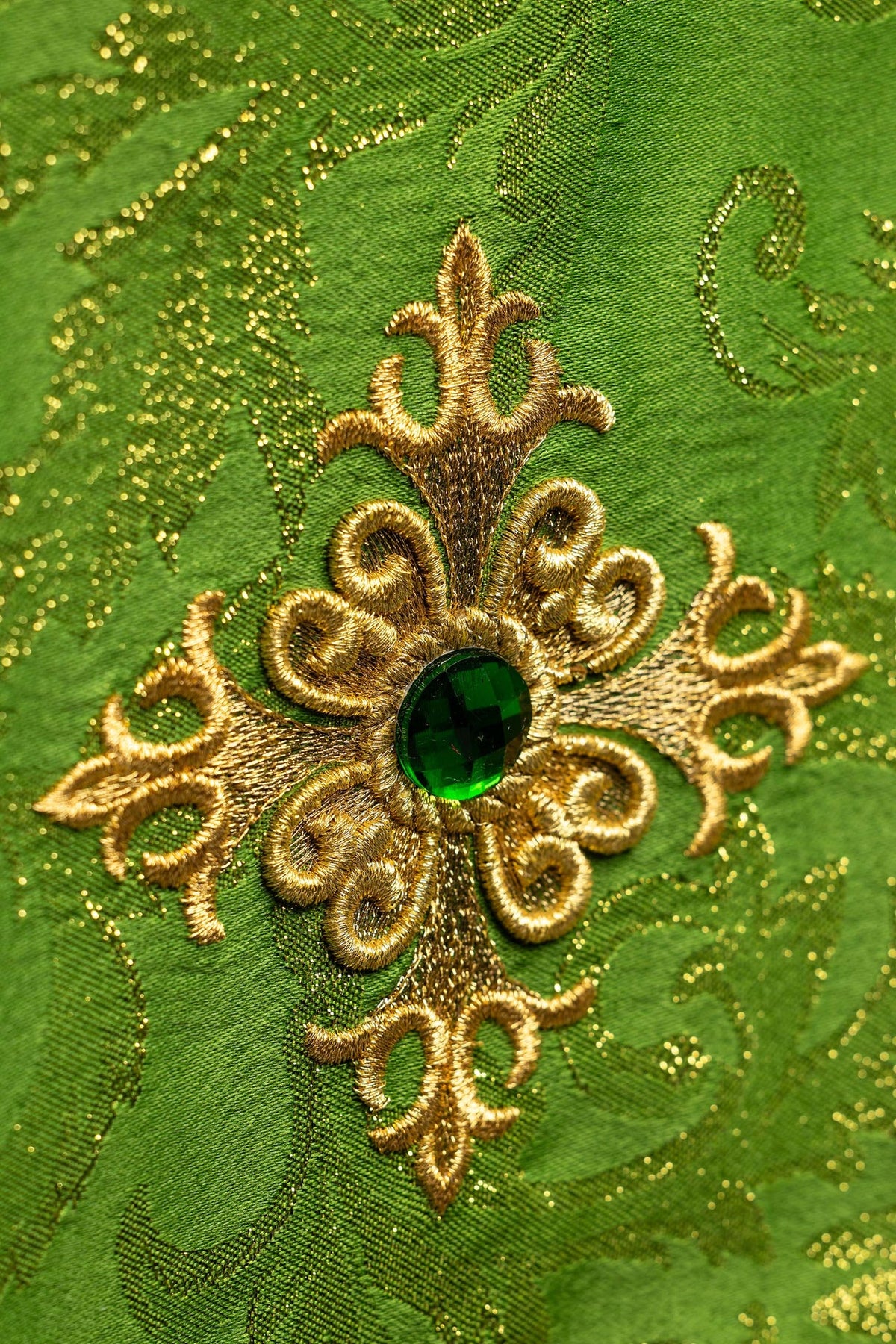 Voile de calice vert, gros plan sur la croix brodée et la pierre verte