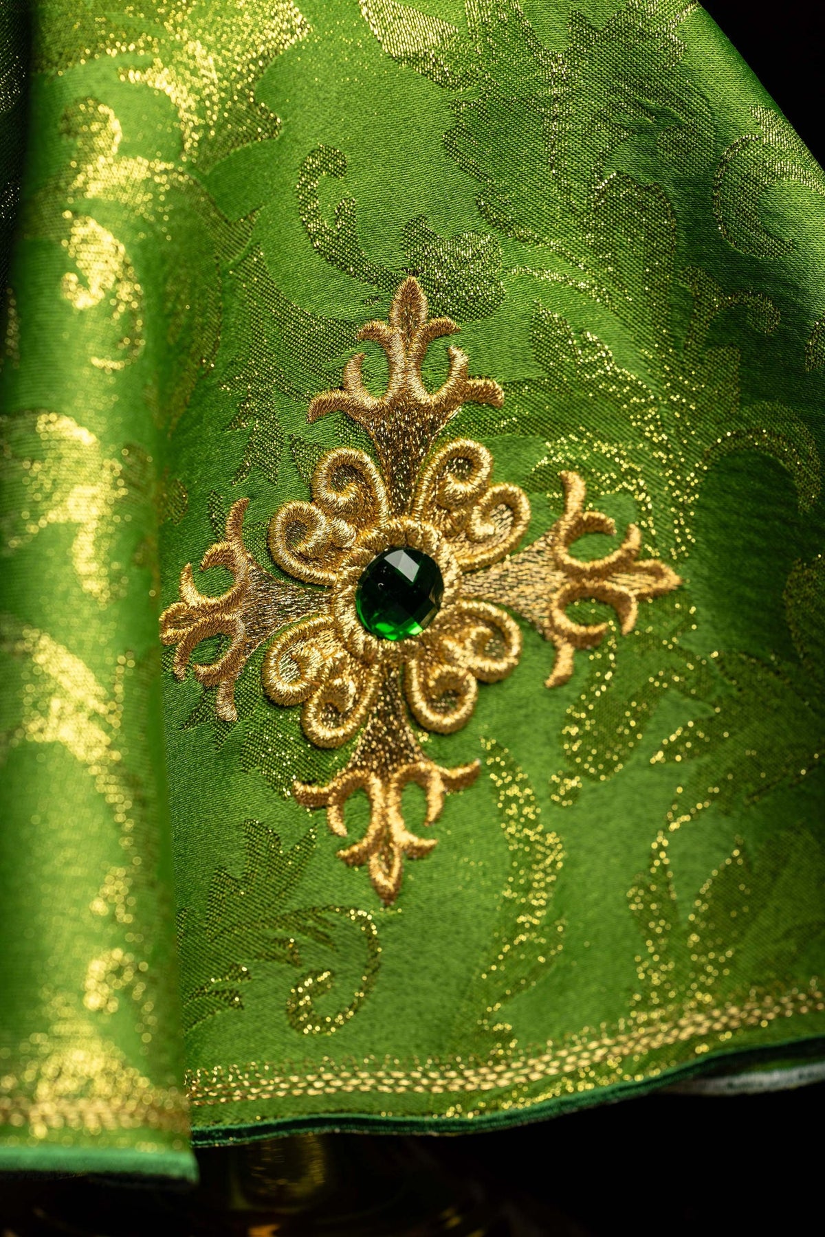 Voile de ciboire vert, gros plan sur la croix brodée et la pierre verte