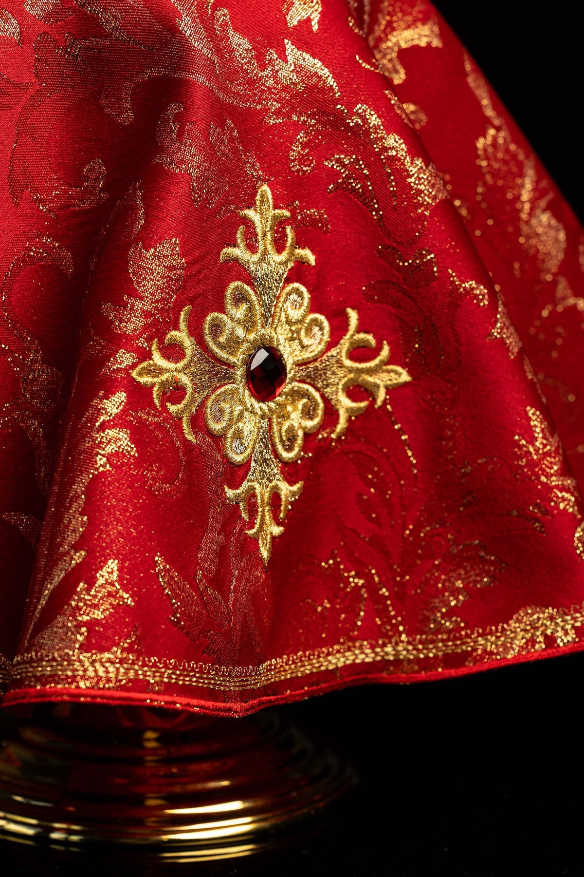 Voile de ciboire rouge brodé, gros plan sur la croix et la pierre décorative