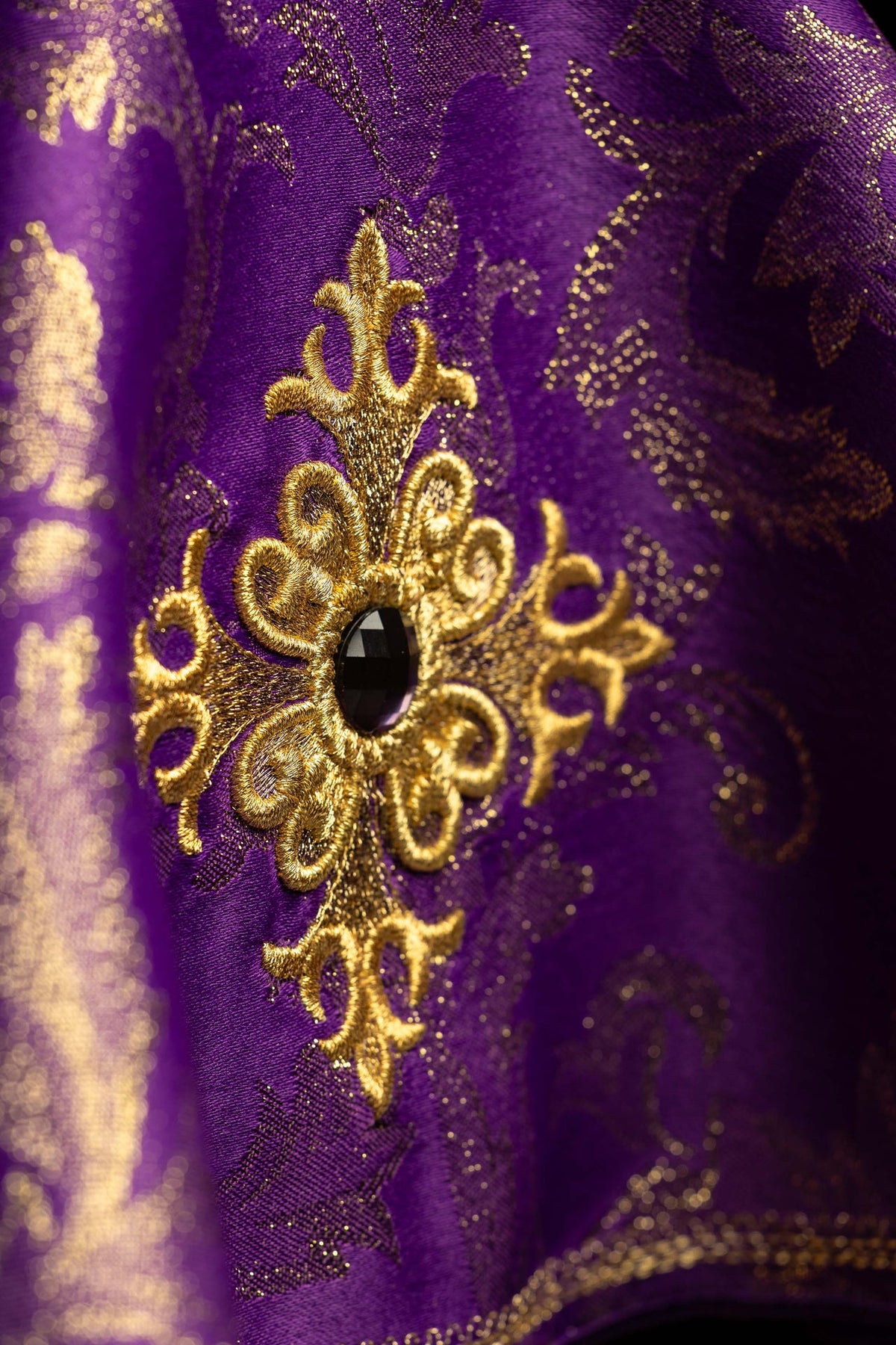 Voile de ciboire violet, gros plan sur la croix brodée et la pierre