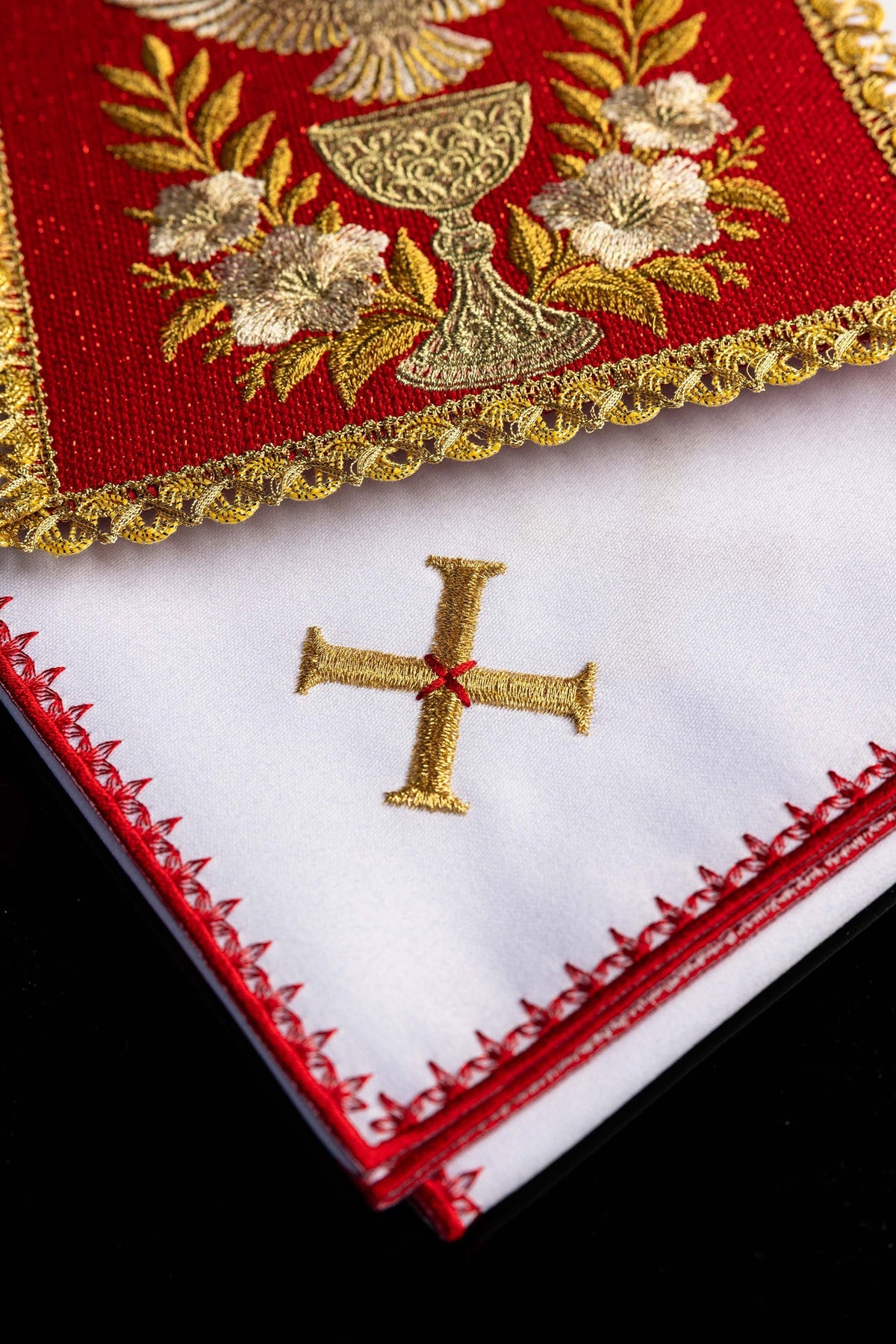 Linge de calice rouge et blanc, détail de la croix dorée et de la bordure rouge brodée