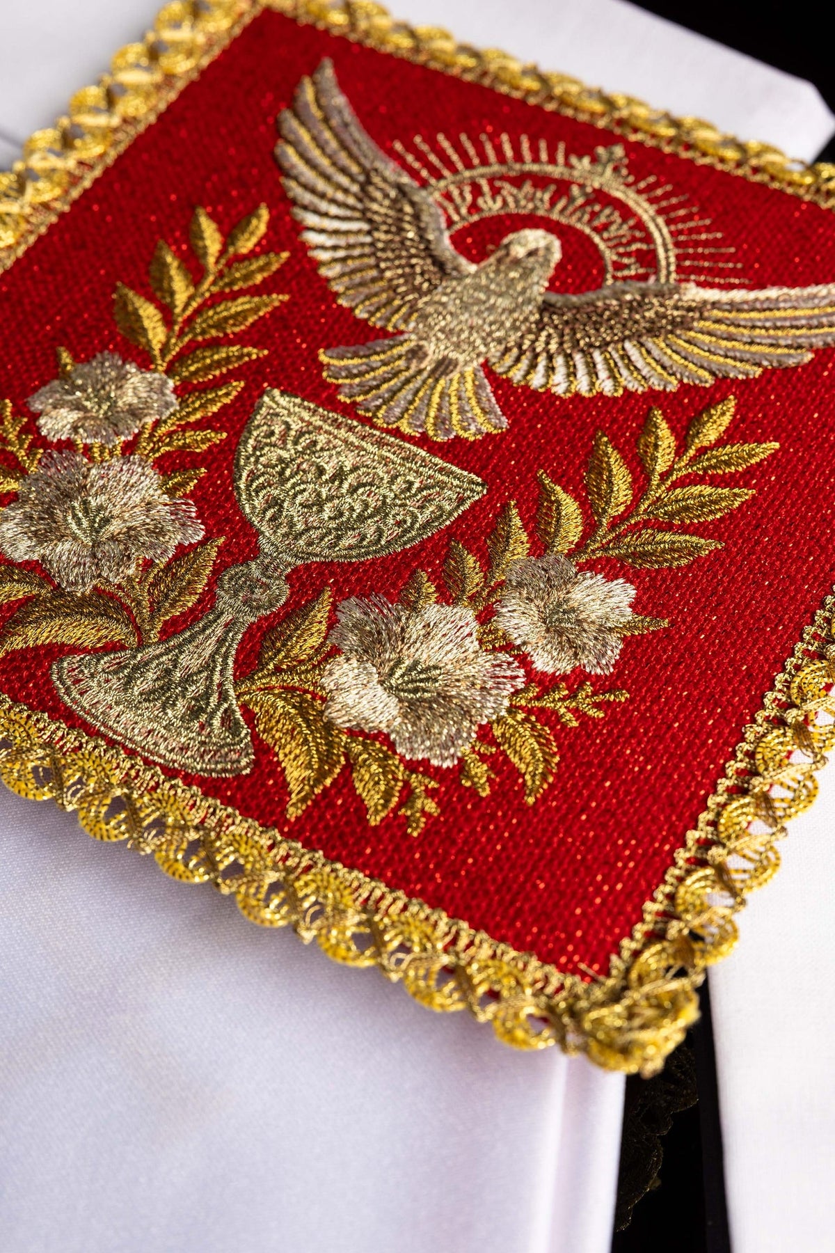Linge de calice rouge, gros plan sur le calice, le Saint-Esprit et la bordure dorée